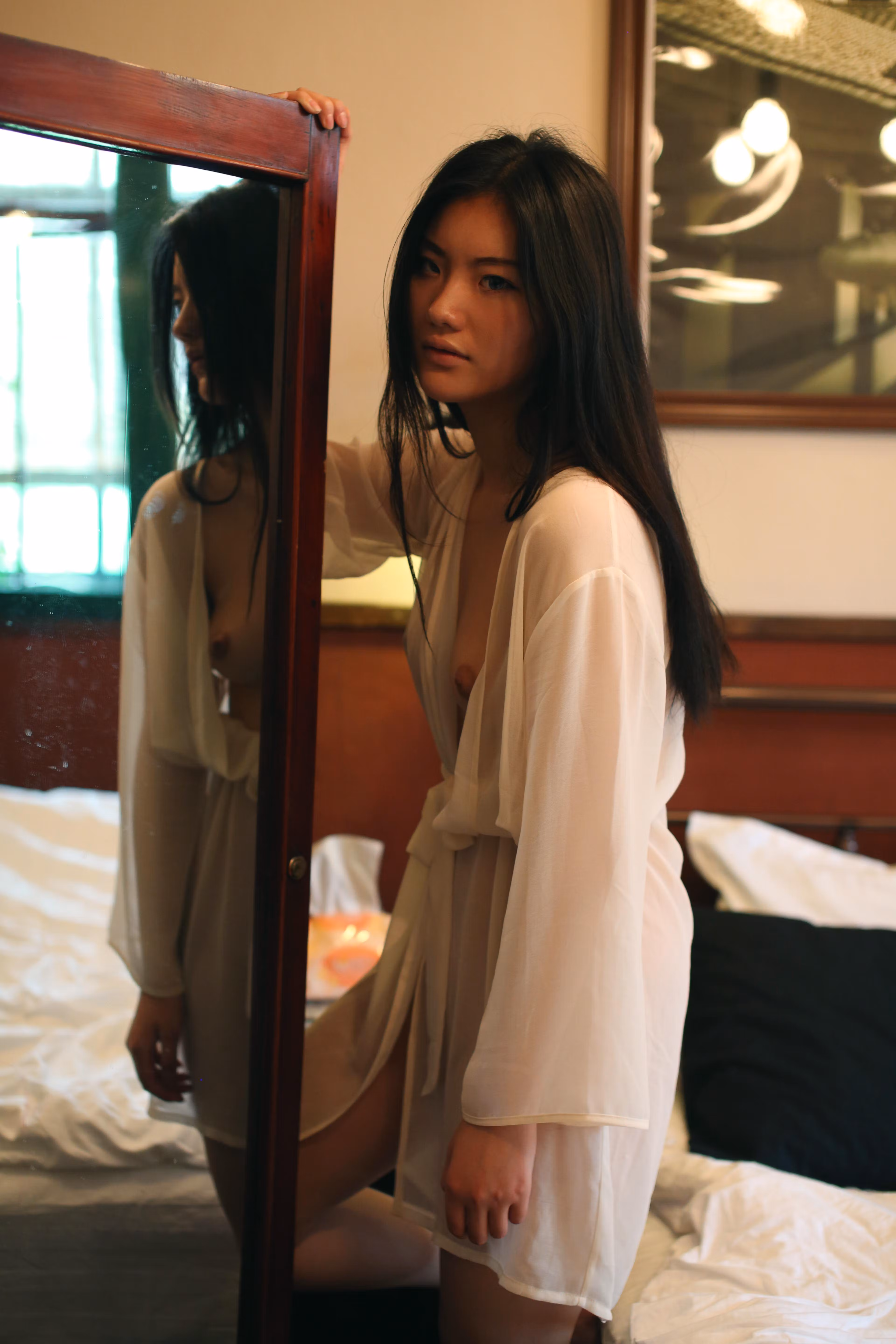 Azhu hugging knees showing slender legs and captivating gaze