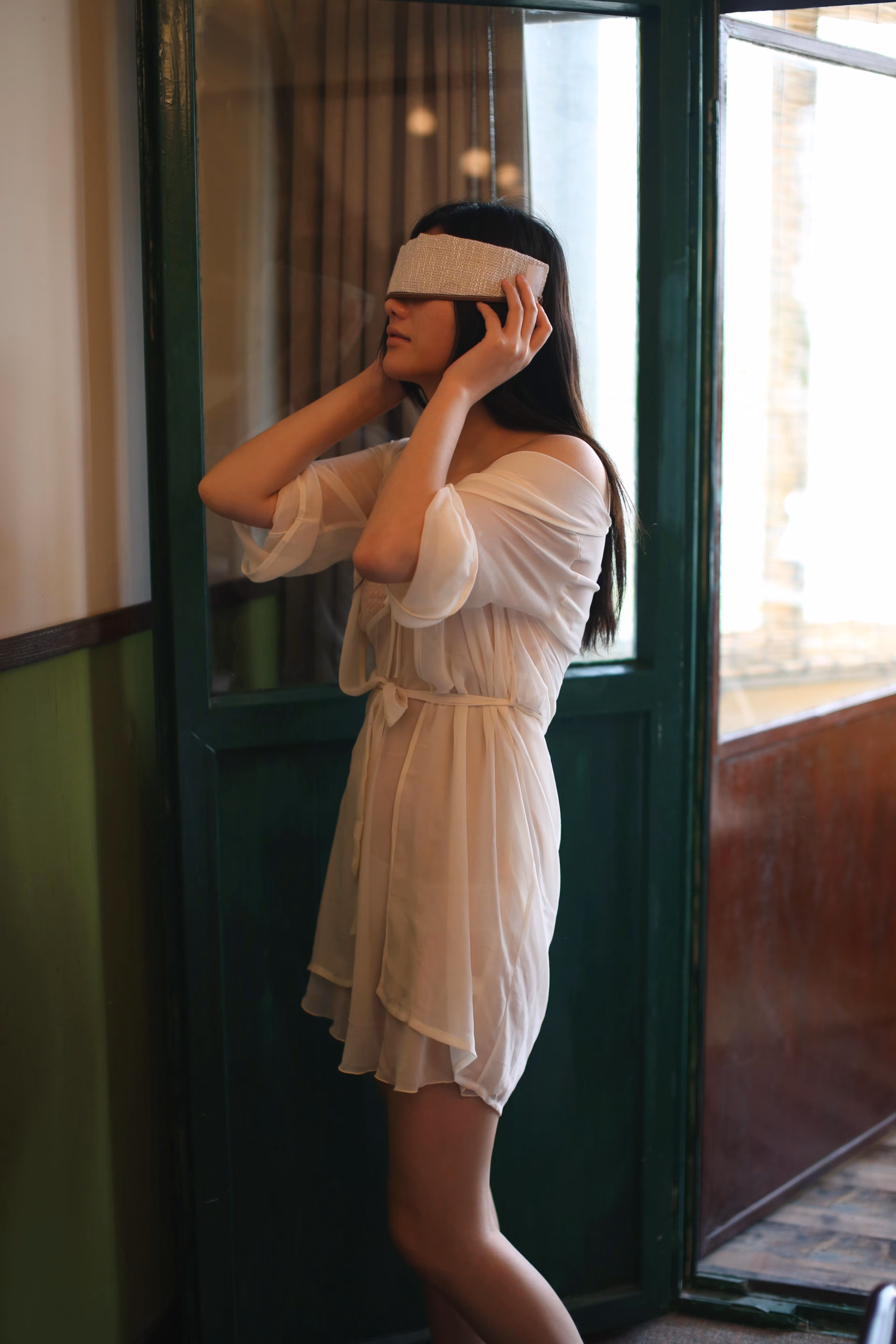 Model Azhu (阿朱) sitting on balcony chair wearing white sheer robe and lace lingerie